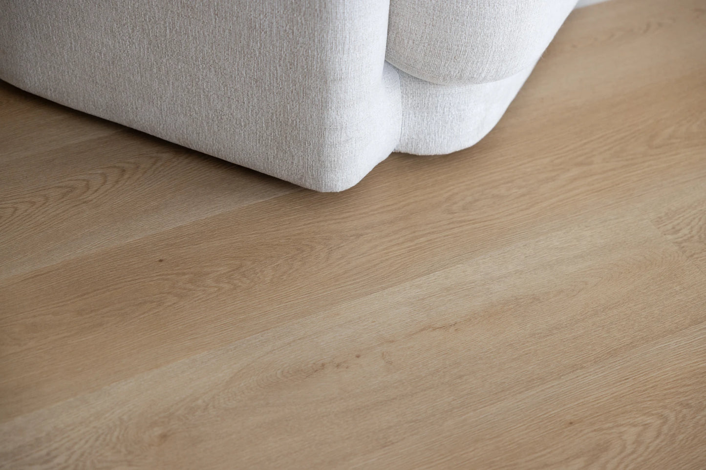 Coastal Collection Bokarina Oak luxury vinyl plank flooring with a cream boucle sofa in a Sunshine Coast living room