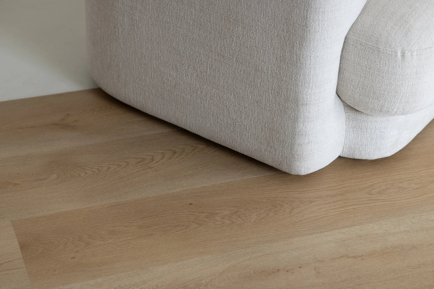 Coastal Collection Bokarina Oak luxury vinyl plank flooring with a cream boucle sofa in a Sunshine Coast living room