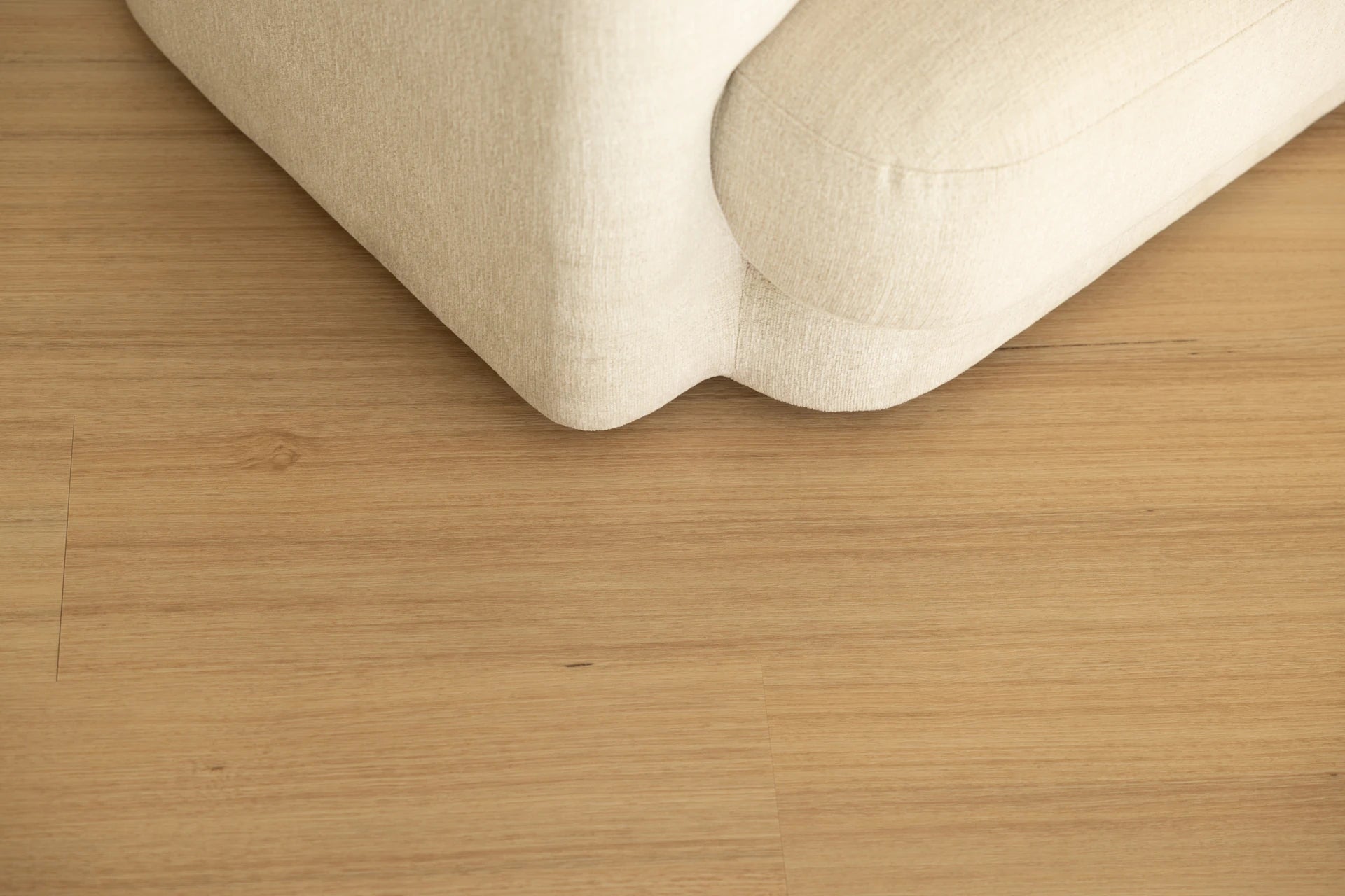 Coastal Collection Noosa Oak luxury vinyl plank flooring with a cream boucle sofa in a Sunshine Coast living room