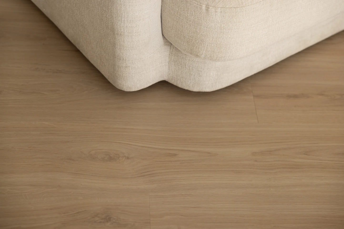 Coastal Collection Sunshine Beach Oak luxury vinyl plank flooring with a cream boucle sofa in a Sunshine Coast living room
