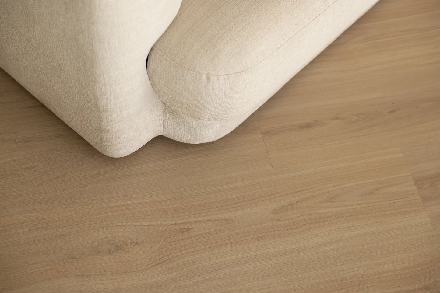 Coastal Collection Sunshine Beach Oak luxury vinyl plank flooring with a cream boucle sofa in a Sunshine Coast living room