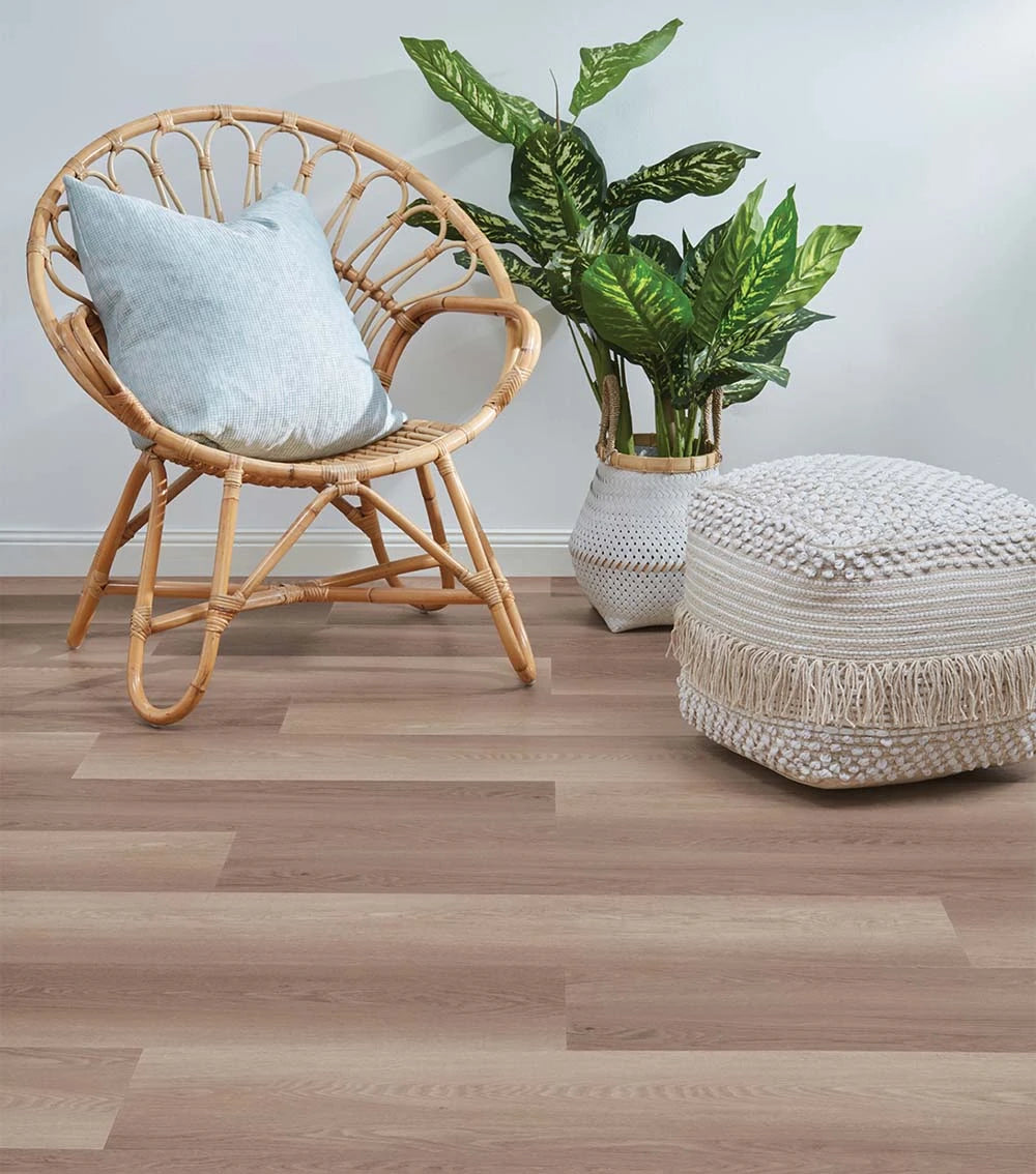 Smoked Oak Vinyl Plank Duskmoor in a coastal sitting area with a rattan chair, indoor plants and woven textures